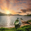 Two canoes at the lakeshore with a beautiful sunrise in the horizon