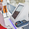 a woman paying at self checkout kiosk
