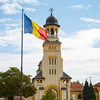 A scenic view of the Romanian flag against the Cathedral of the Coronation in Alba Iulia