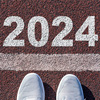 A person shoe on an athletics track engraved with the year 2024