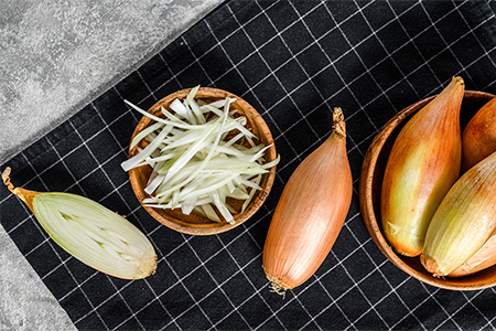 Yellow raw shallot onions, Grated and halved, Gray background. Top view.