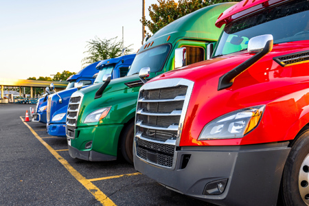 Colorful Pickup trucks parked in a parking lot.