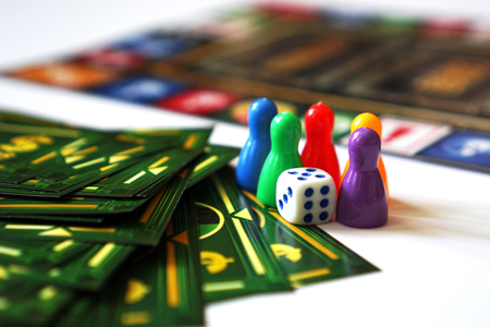 Board game Monopoly with money and plastic chips. No logos or visible brands - white background