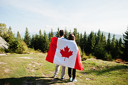 Couple with large Canadian flag celebration in mountains