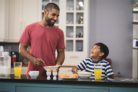 young father with his son making breakfast in kitchen