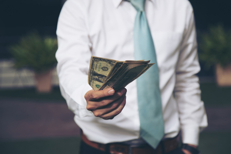 man holding banknote money to forward for solving one's problem