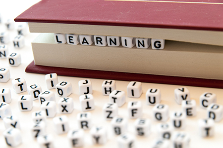 Word learning written with letters between a book pages