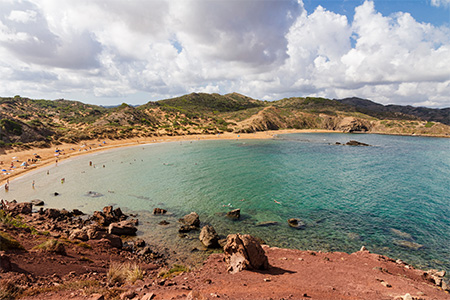 Amazing beach between hills with red sand and emerald sea, island