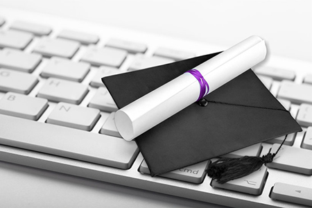 graduation cap and diploma on keyboard