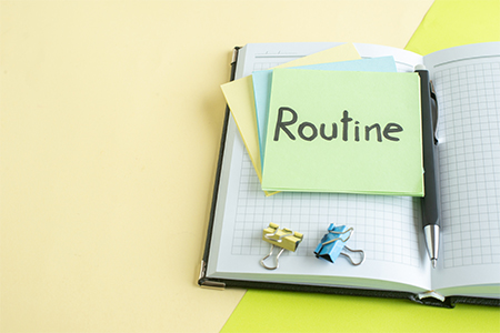 front view routine written note with stickers and notepads on yellow-green background college