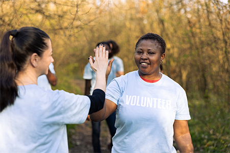 Team leader sharing a high five with her colleague, praising each other and feeling pleased