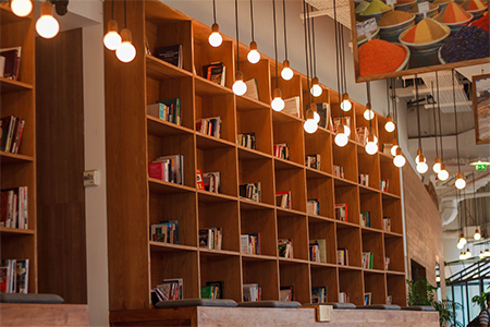 Books Inside Bookshelf Near Lit Pendant Lights in Library