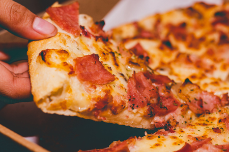 Close-Up Photo of Person Holding Pizza