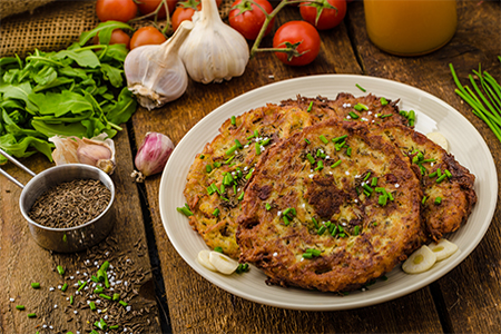 Fried potato pancakes with garlic and marjoram, sprinkled cumin, chive and coarse-grained salt