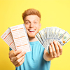 Happy young man holding lottery tickets and money