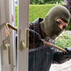 burglar at a window trying to break into house