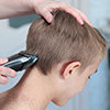 Blond boy gets haircut at home during quarantine isolation. 