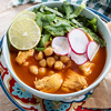 Traditional mexican red pozole soup on wooden table