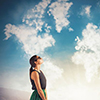 clouds forming world map - woman looking up