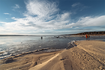 two people walk along the coast