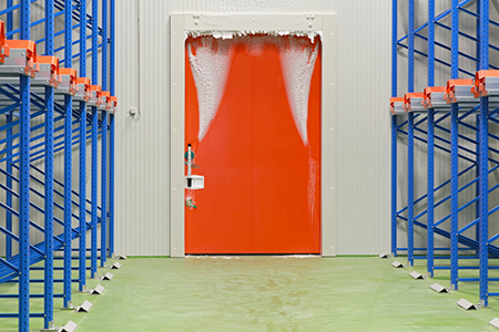 Warehouse freezer door covered in ice and frost