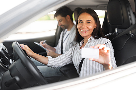 Instructor Man Taking Notes While Happy Driver Pretty Young Woman Showing Her Driving License