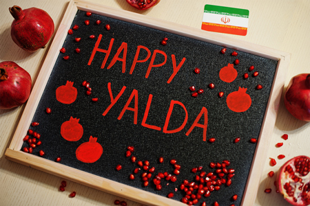 Happy Yalda night written on the board, pomegranate inscription on blackboard