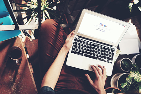 Young man sign up google page. Generic design laptop is on his knees. Social network screen, horizon