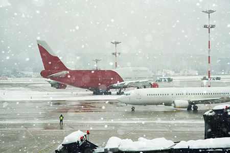 Airport terminal under winter snowfall.