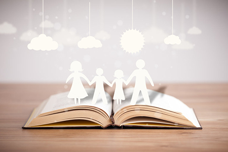 Open book with cardboard cutout of family - story concept