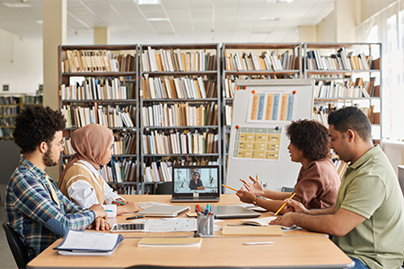 Group of foreign students studying while sitting in the library