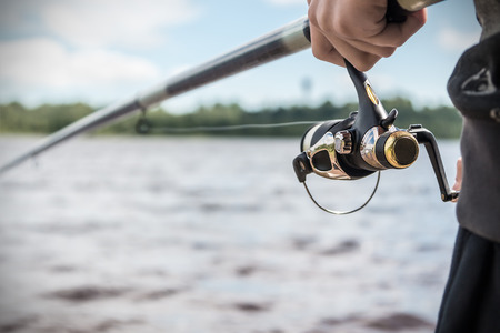 fisherman holding reel close up