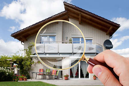 Person Hand With Magnifying Glass Over Luxury House