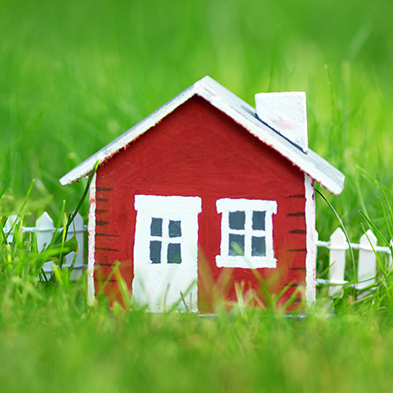 Red wooden house on the grass.