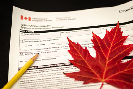 Canada immigration form with pencil and maple leaf