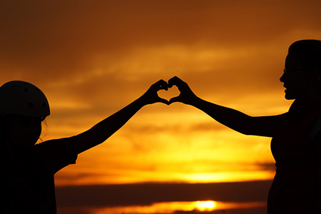 mother and  daughter making heart shape with hands