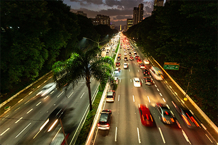 view from the top of a busy avenue, with cars speeding by