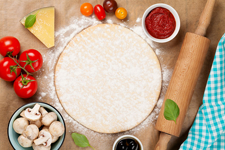 Pizza cooking ingredients. Dough, vegetables and spices. Top view with copy space