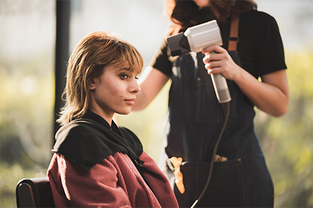 hairdresser combing a young woman's hair