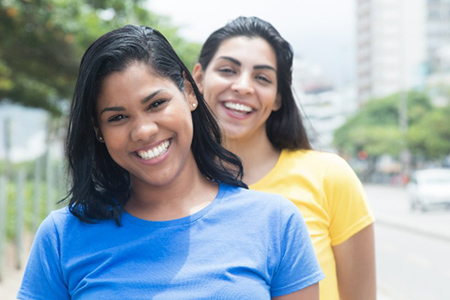 Two mexican girlfriends in colorful shirts in the city