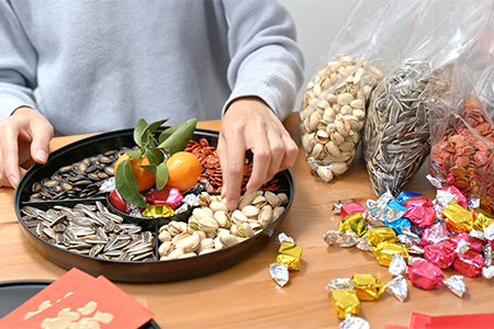 Woman fill with snack of the box for Iranian New Year