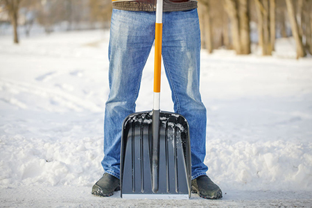 Man with a snow shovel on the trails