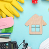 House with cleaning products on light blue background.