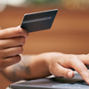 Close up of a woman using a laptop and holding a credit card