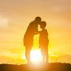 Silhouette of a mother kissing his son in a forehead on the sunset summer day.