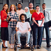 A diverse group of young business people walking a corridor in the glass-enclosed office