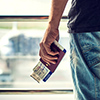 Closeup of man holding passports and boarding pass at airport