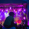 Child sits on the neck of a man laser light background.At the concert