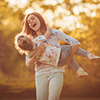 Mother and little daughter playing together in a park