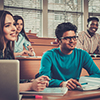 Multinational group of cheerful students taking an active part in a lesson while sitting in a lectur